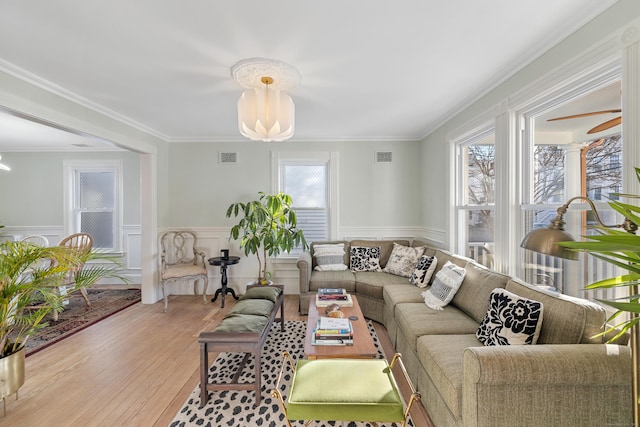 living room with crown molding, a healthy amount of sunlight, and hardwood / wood-style flooring