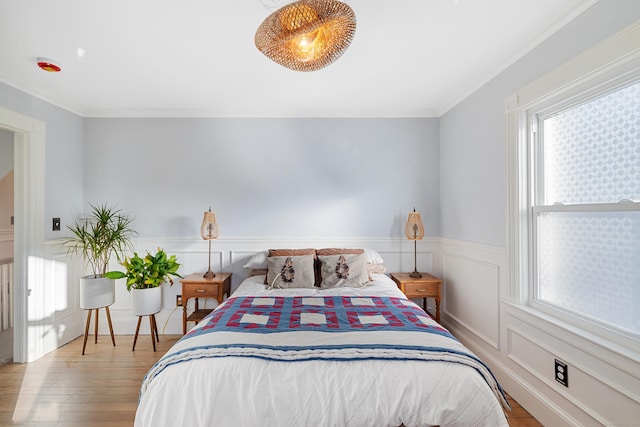 bedroom with ornamental molding and light hardwood / wood-style floors