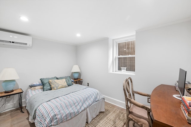 bedroom with a wall mounted AC and light hardwood / wood-style floors