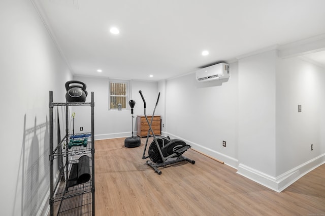 exercise room featuring ornamental molding, a wall unit AC, and light hardwood / wood-style flooring