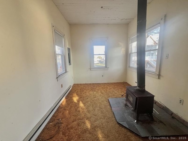 interior space with a baseboard radiator and a wood stove