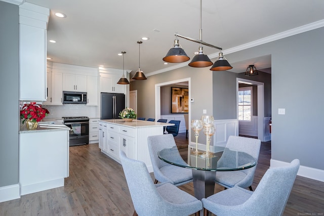 dining room with hardwood / wood-style floors and crown molding