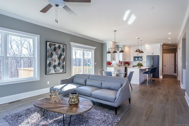 living room featuring ceiling fan, dark hardwood / wood-style floors, and ornamental molding