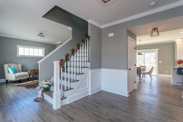 staircase featuring wood-type flooring and ornamental molding