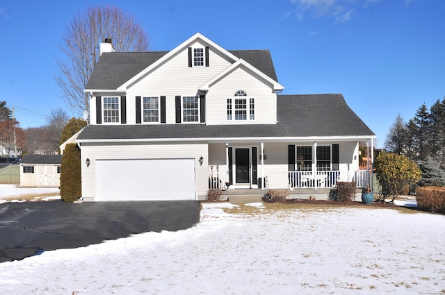 view of property with a porch, a garage, and a storage shed