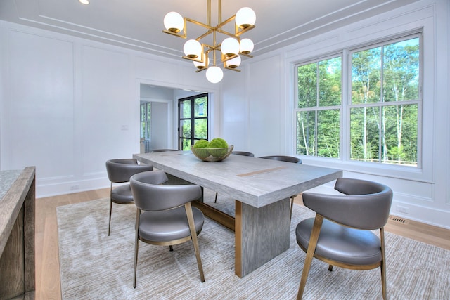 dining space featuring a notable chandelier and light hardwood / wood-style floors