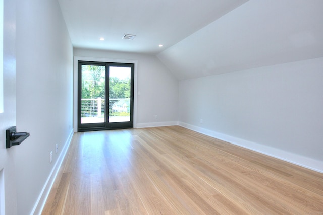 additional living space featuring light hardwood / wood-style floors and lofted ceiling