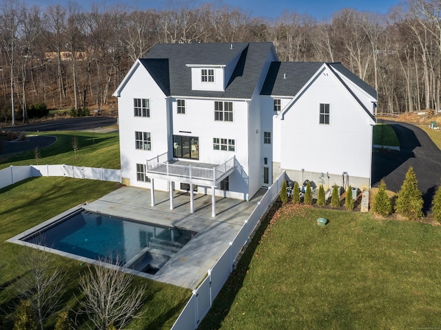 rear view of property with a fenced in pool, a yard, and a patio