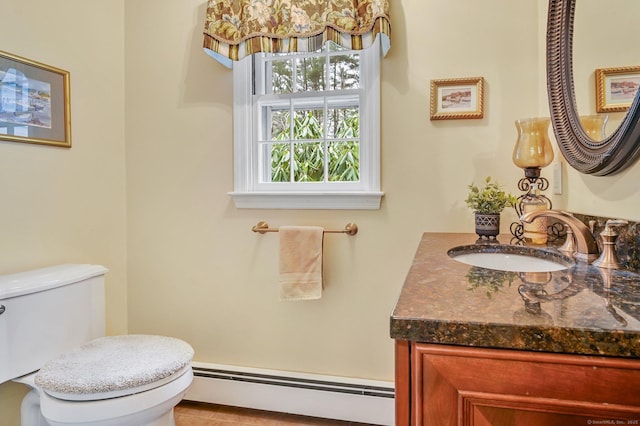 bathroom featuring toilet, vanity, and a baseboard heating unit