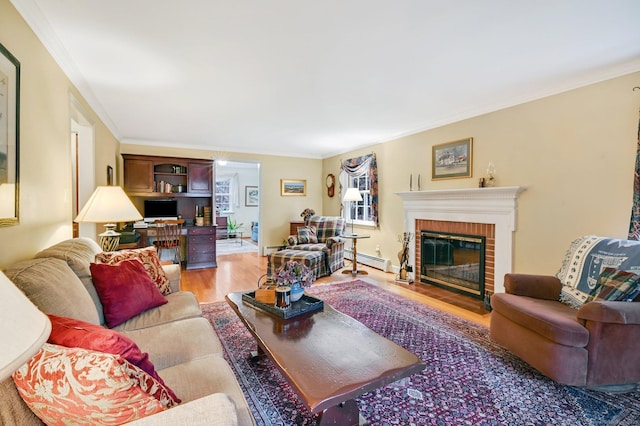 living room with ornamental molding, light hardwood / wood-style flooring, a baseboard radiator, and a brick fireplace