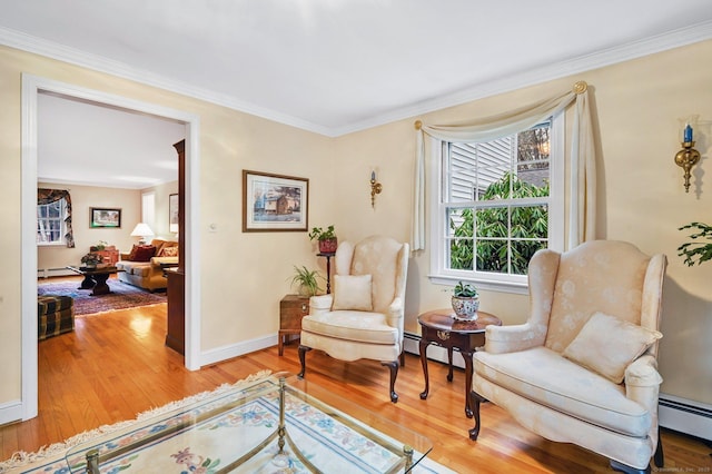 sitting room featuring baseboard heating, crown molding, and hardwood / wood-style floors