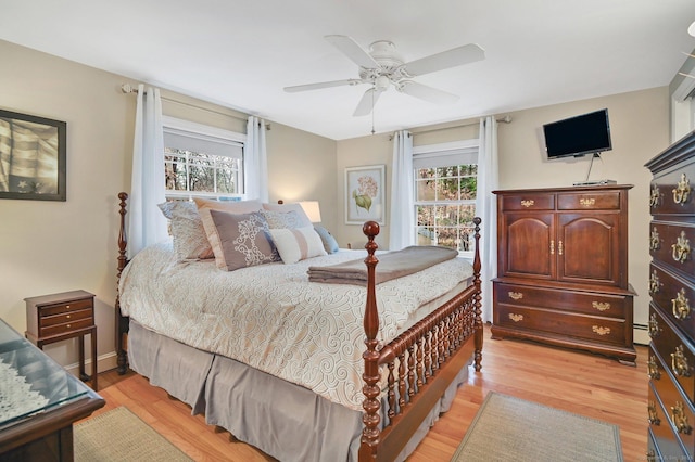 bedroom with multiple windows, ceiling fan, and light hardwood / wood-style flooring