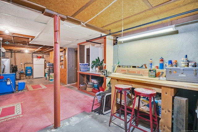 basement featuring a workshop area and white refrigerator