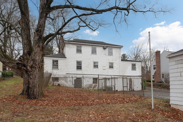 rear view of property with central AC