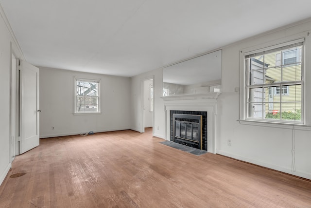 unfurnished living room featuring a tile fireplace and light wood-type flooring