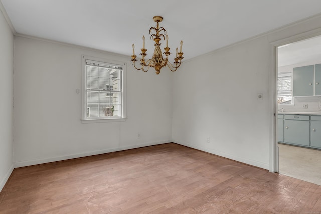 unfurnished room featuring crown molding, a chandelier, and light wood-type flooring