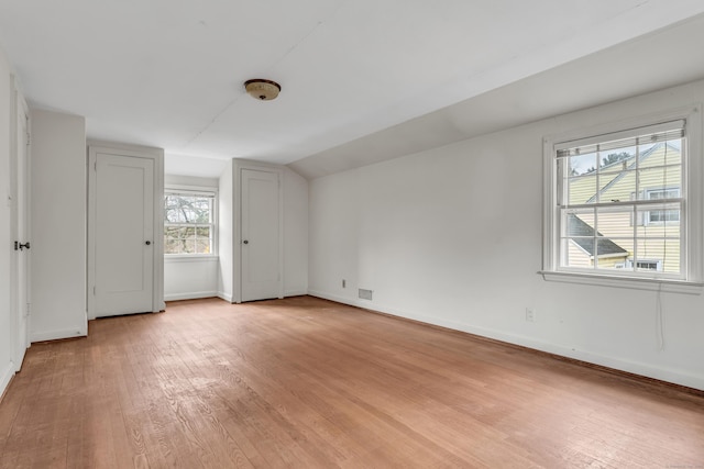 unfurnished bedroom with light hardwood / wood-style floors and vaulted ceiling