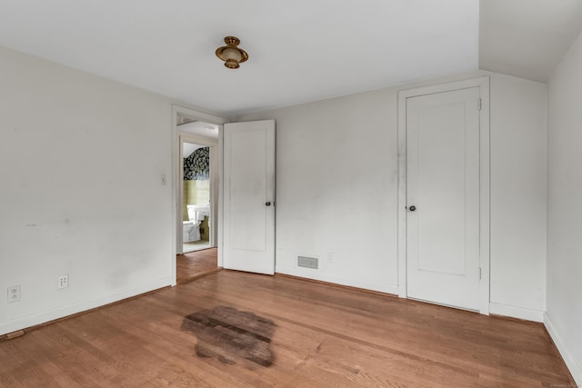 unfurnished bedroom featuring light hardwood / wood-style flooring and vaulted ceiling