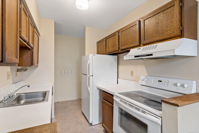 kitchen with a textured ceiling, white appliances, light tile patterned floors, and sink