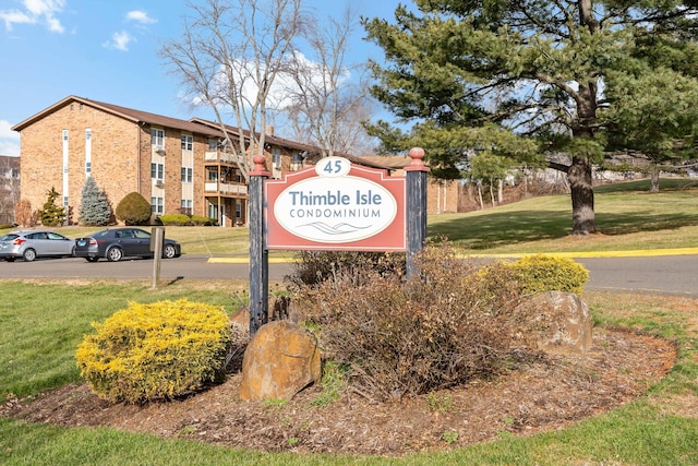 community / neighborhood sign featuring a yard