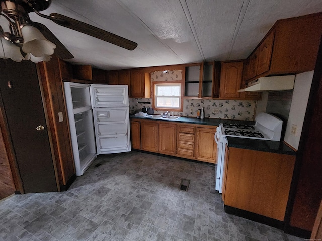 kitchen featuring ceiling fan, white gas range, and sink