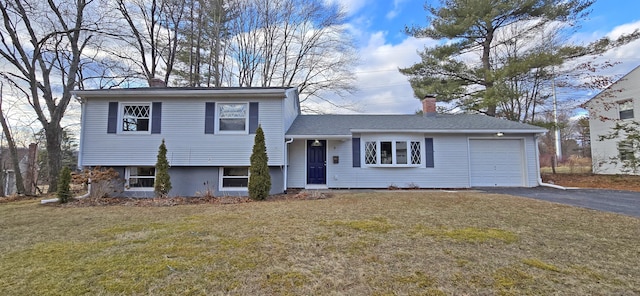 split level home with a garage and a front lawn