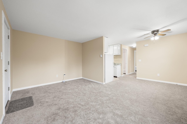 unfurnished room featuring ceiling fan and light carpet