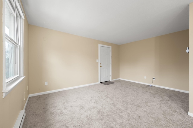 carpeted empty room with baseboard heating