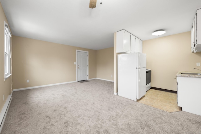 kitchen with light carpet, a baseboard heating unit, white refrigerator, range with electric cooktop, and white cabinetry