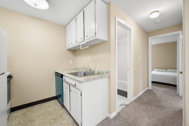 kitchen with stainless steel dishwasher, white cabinetry, sink, and light carpet