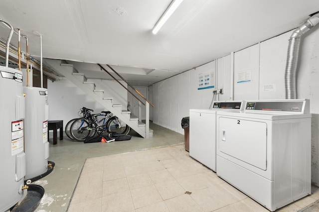 clothes washing area featuring electric water heater and washing machine and clothes dryer