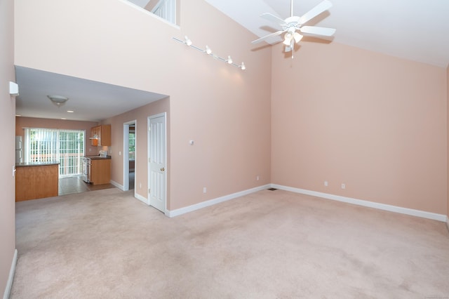 unfurnished living room featuring light colored carpet and a towering ceiling