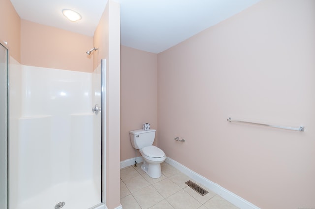 bathroom featuring tile patterned flooring, toilet, and walk in shower