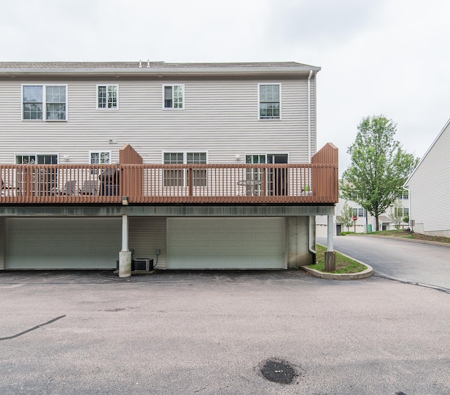 back of property featuring a garage and central air condition unit