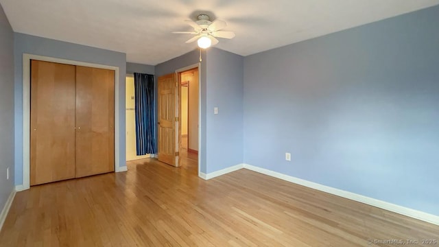 unfurnished bedroom with ceiling fan, a closet, and light hardwood / wood-style flooring