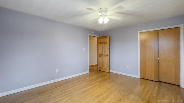 unfurnished bedroom featuring ceiling fan, a closet, and light hardwood / wood-style floors