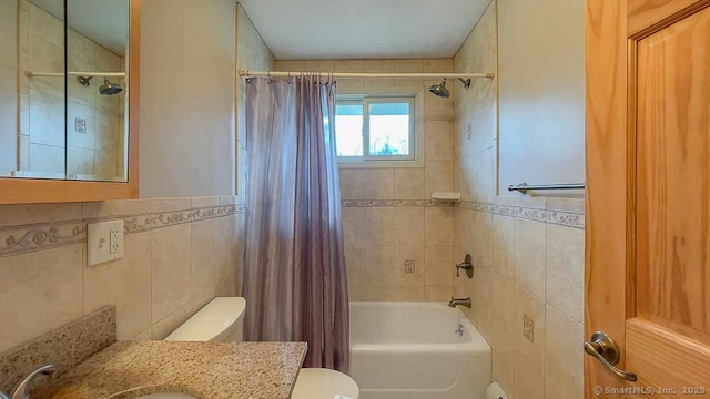 full bathroom with toilet, vanity, tile walls, and shower / bathtub combination with curtain