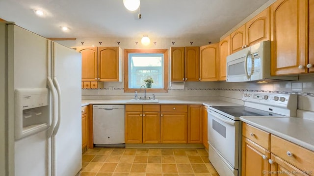 kitchen featuring decorative backsplash, sink, and white appliances