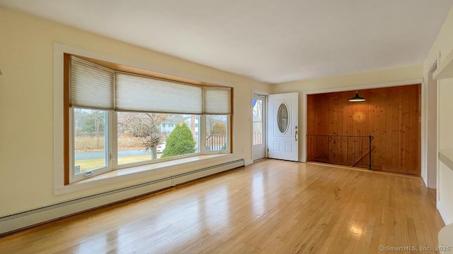 foyer entrance with light hardwood / wood-style floors and a baseboard heating unit