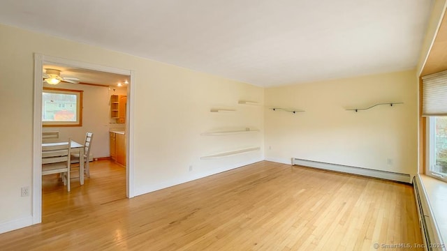 unfurnished room featuring light wood-type flooring and a baseboard radiator