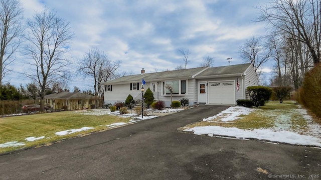 single story home with a front yard and a garage