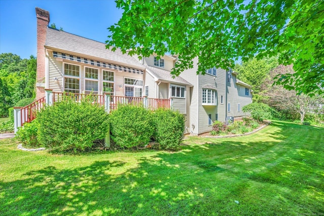 rear view of house featuring a lawn