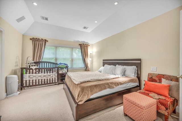 bedroom featuring light colored carpet, a raised ceiling, and lofted ceiling