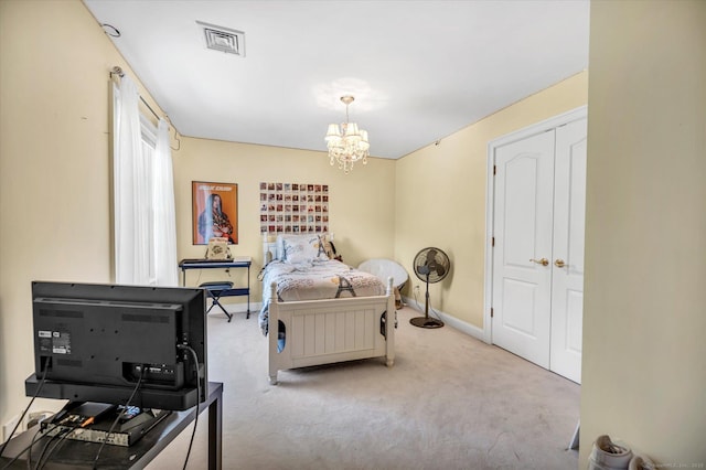 bedroom featuring a closet, light colored carpet, and an inviting chandelier