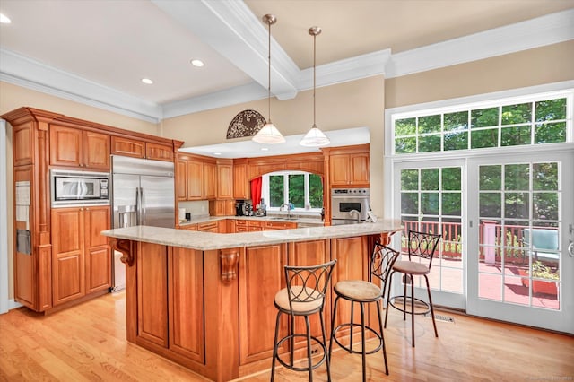 kitchen with light stone countertops, hanging light fixtures, beamed ceiling, built in appliances, and crown molding