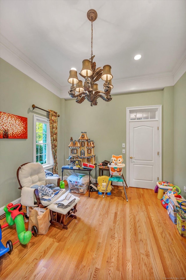 rec room with a notable chandelier, wood-type flooring, and crown molding