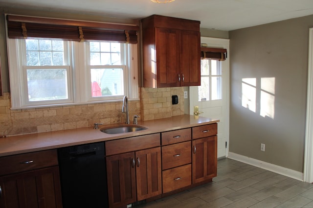 kitchen featuring tasteful backsplash, light hardwood / wood-style floors, black dishwasher, and sink