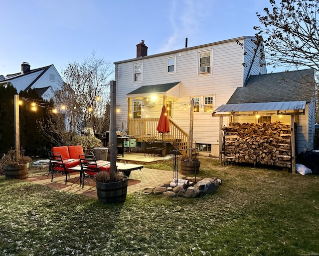 rear view of property featuring a patio area, a chimney, and a lawn