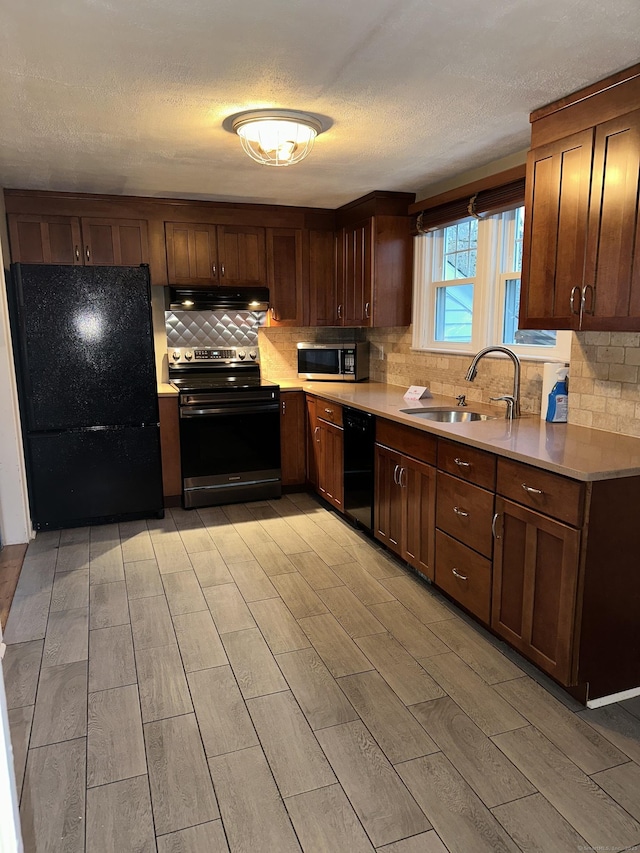 kitchen with sink, decorative backsplash, black appliances, and a textured ceiling