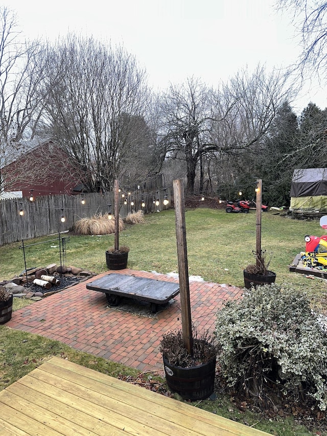 wooden terrace featuring a patio and a yard